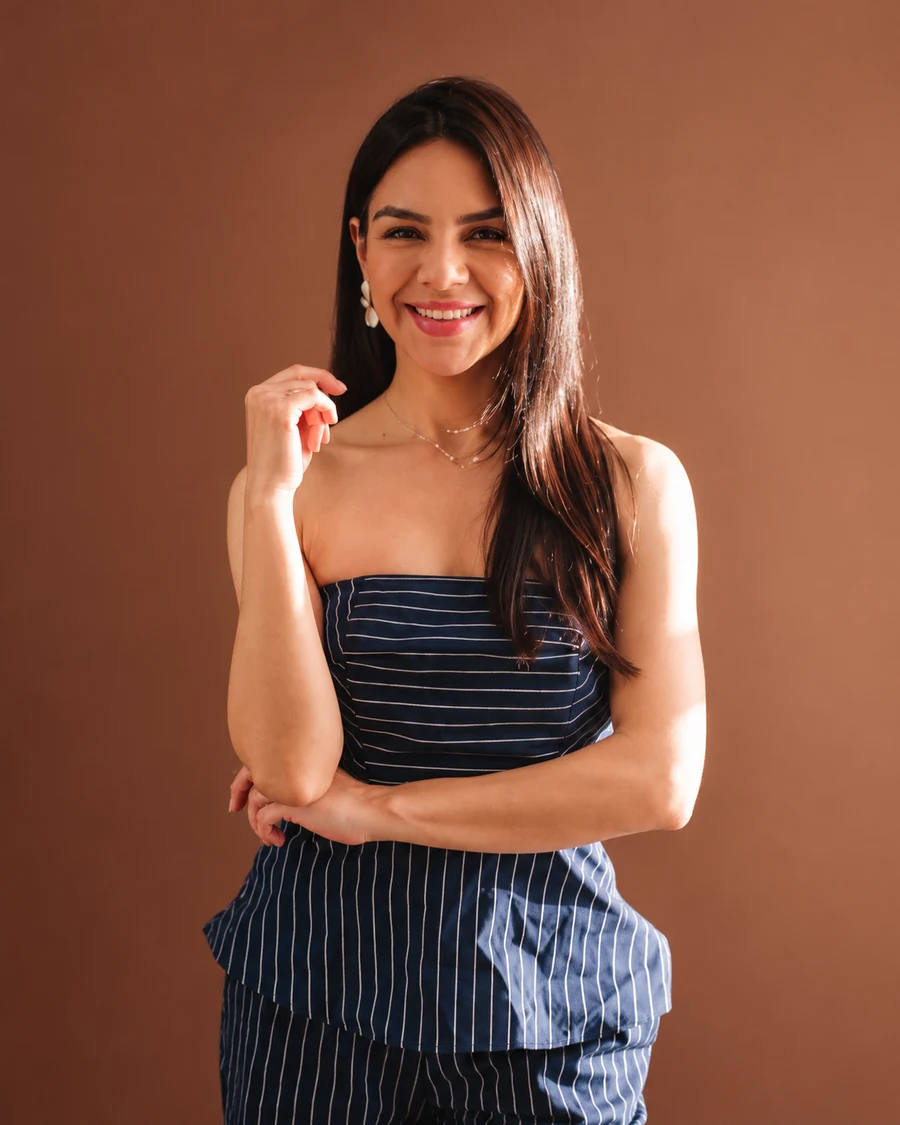 Camila Vargas sorrindo, de conjunto listrado azul-marinho